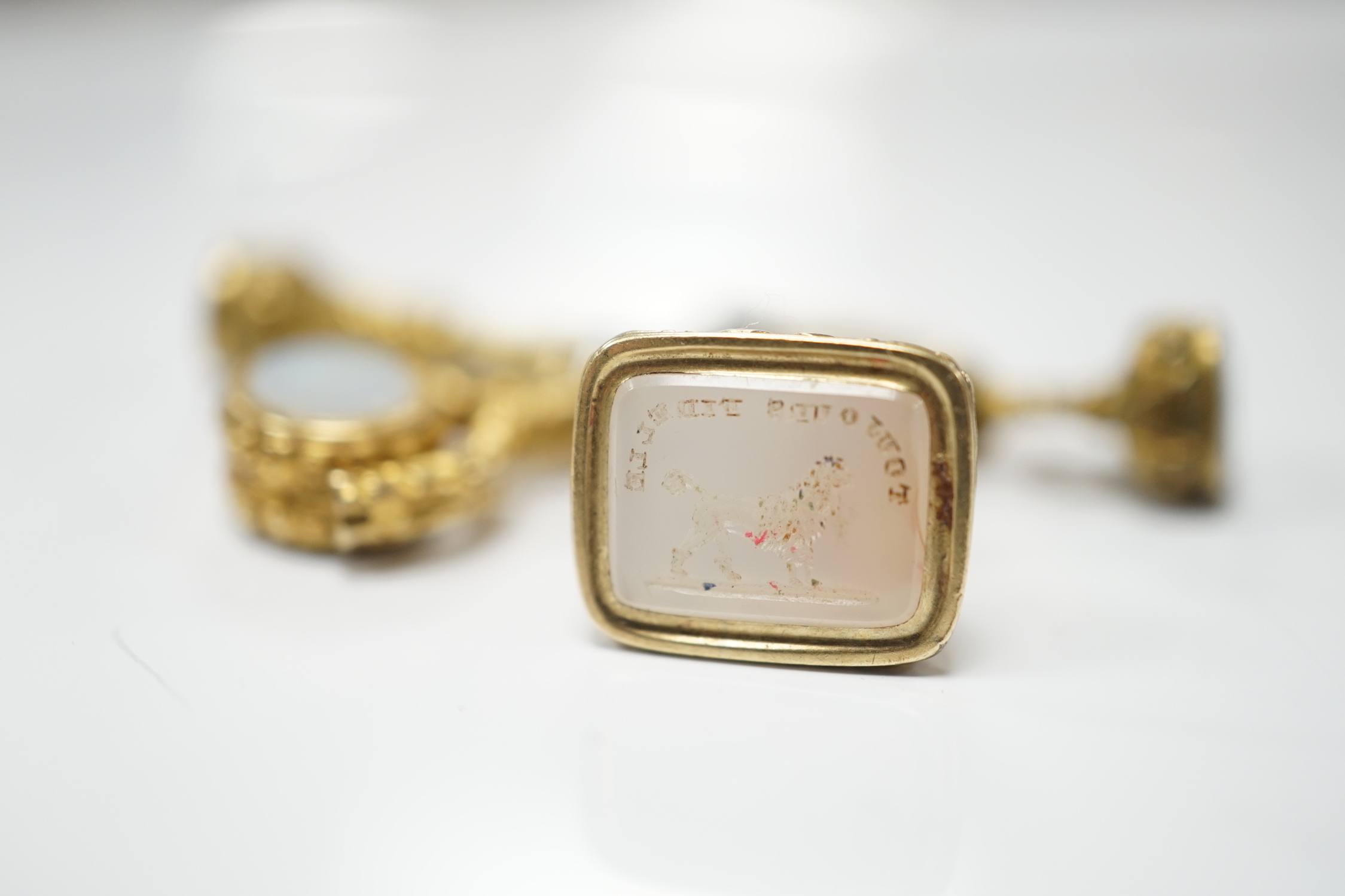 Three assorted 19th century yellow metal overlaid and chalcedony set fob seals and one other item, all mounted on a loop ring, largest approx. 20mm.